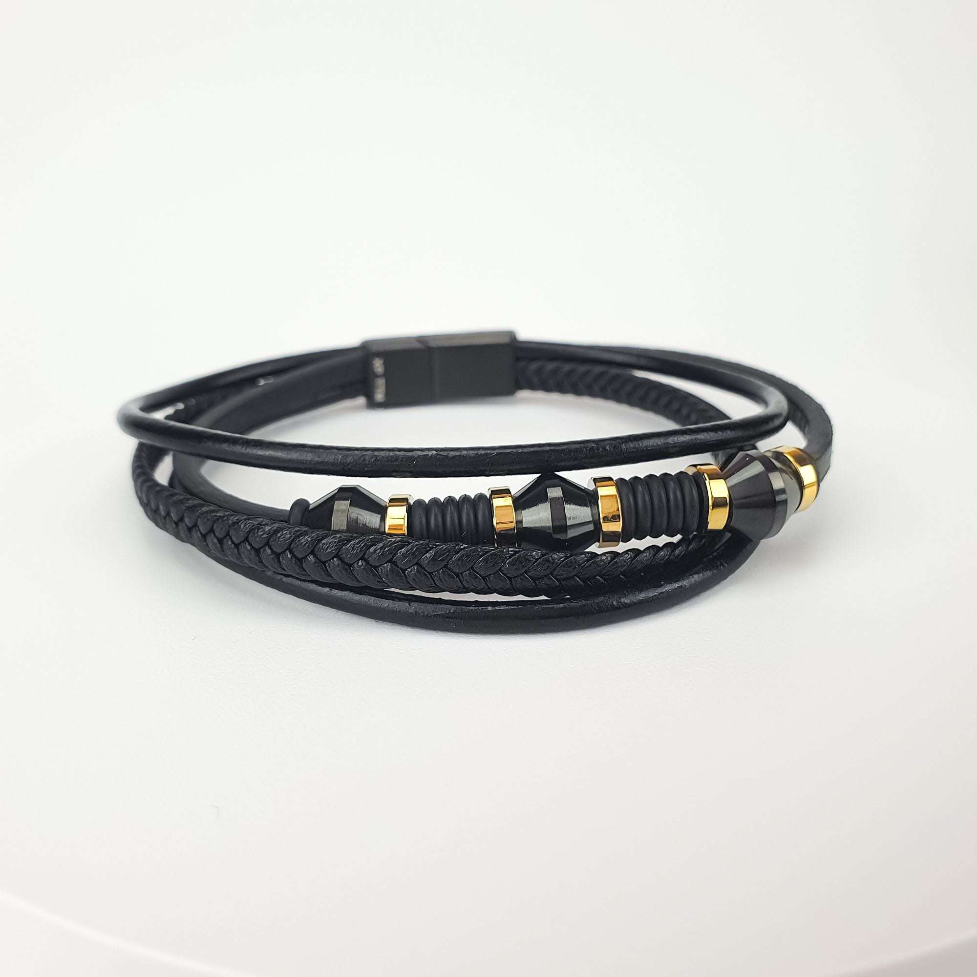 Melnas ādas rokassprādze ar ģeometriskām detaļām un zelta ielaidumiem