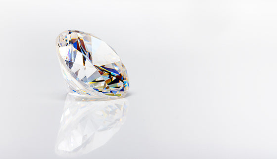 Baltas krāsas, dzirkstošs dabīgais cirkons ar daudzšķautņainu slīpējumu, izcelts uz neitrāla fona