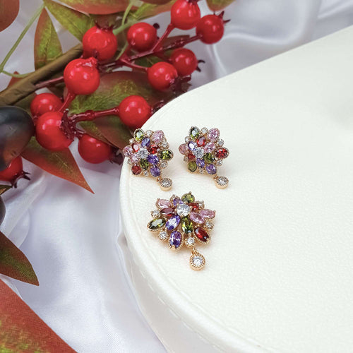 Grezns rotu komplekts ar sarkaniem, zaļiem, violetiem un caurspīdīgiem akmeņiem