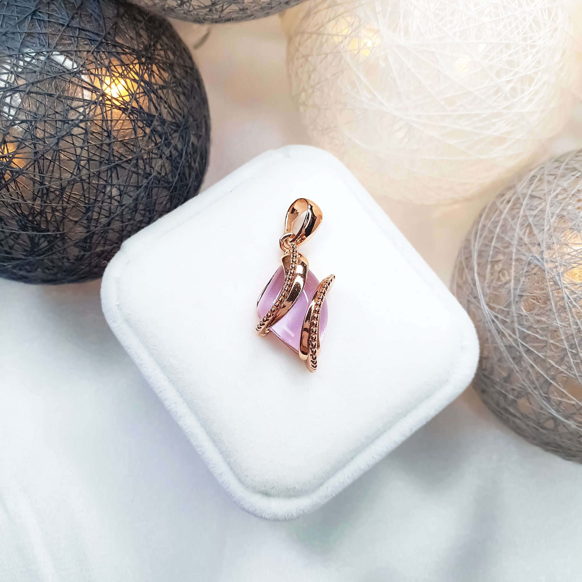 Kulons ar maigi rozā cirkonu un apzeltītu ietvaru