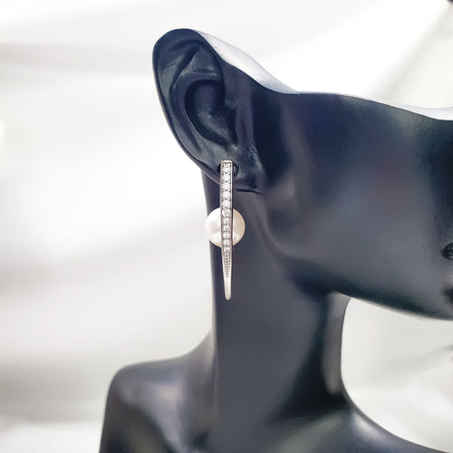 Auskari ar V-veida rāmi balto akmentiņu klājumu un angļu tipa aizdari