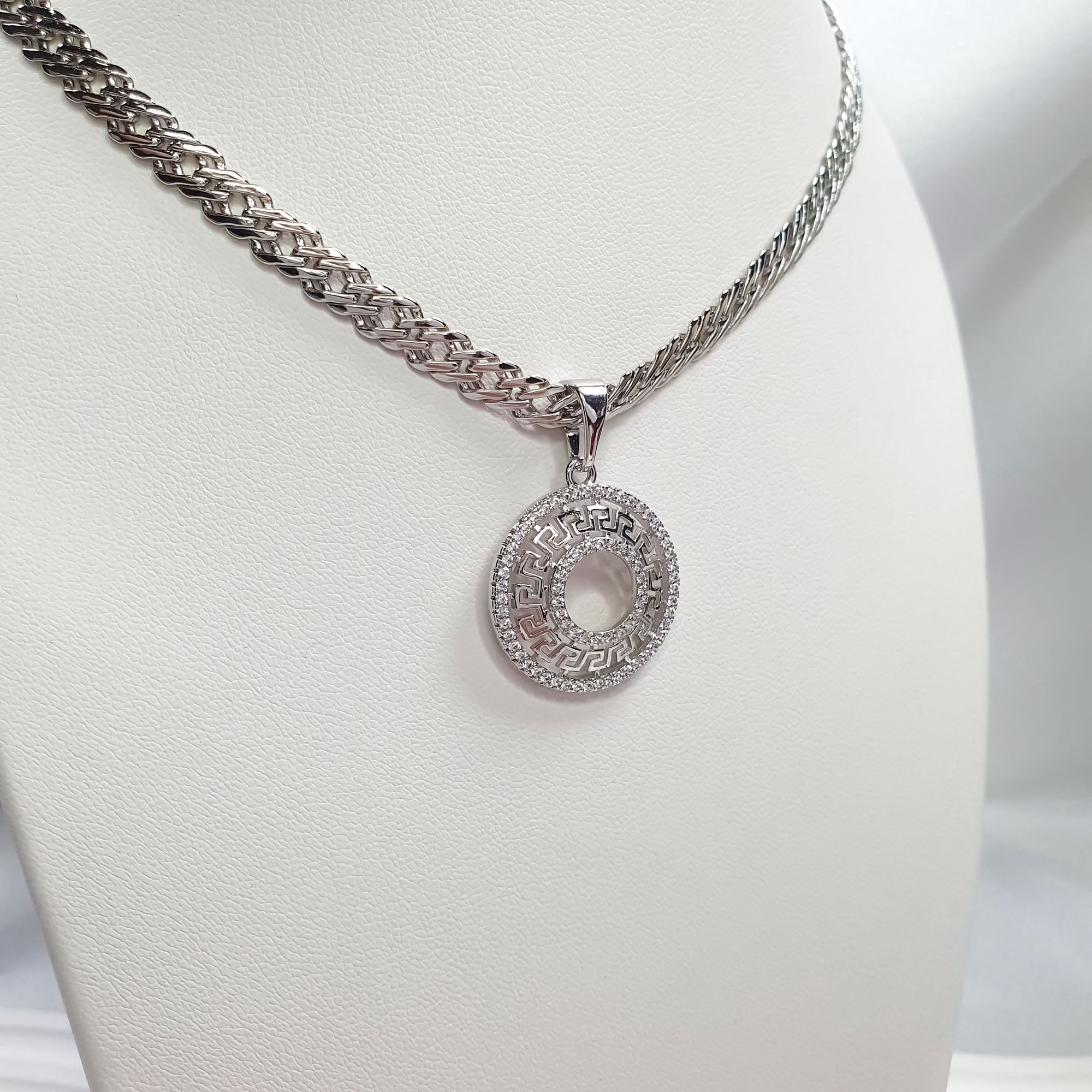 Sudraba krāsas apaļš piekariņš ar divām mirdzošu akmeņu rindām